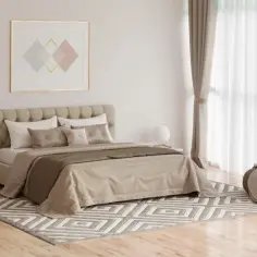 Elegancka sypialnia z łóżkiem, dywanem i drewnianymi podłogami do sypialni.
