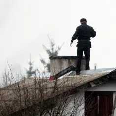 Kominiarz na dachu. Zastanawiasz się, ile kosztuje usługa kominiarska? Sprawdź ceny!