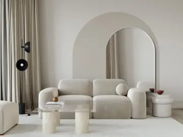 Nowoczesny salon z beżową kanapą i łukiem na ścianie. Lustro w kształcie łuku dodaje głębi.